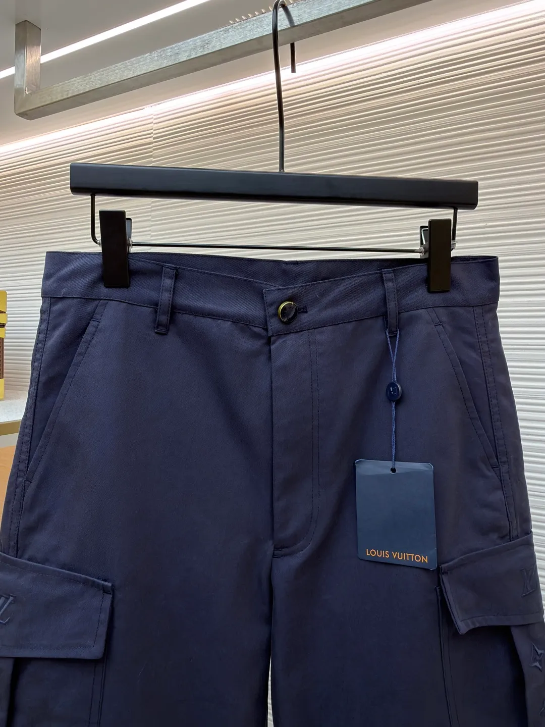 LOUIS VUITTON pocket embroidered work trousers ●Original version: Purchased and developed for 9999 ●Item number: 1681825-B50 ●Fabric: cotton twill fabric ●Technology: embroidery production ●Color: navy blue ●Version: fitted version ●Weight: about 520 grams ●Size: 44-46-48-50 ●Description: The high cotton content ensures the fabric's excellent breathability, durability and classic workwear texture, while the twill weave gives it unique wear resistance and stiffness. The special fabric technology solves the pain points of tight and stiff traditional overalls; it provides greater freedom when moving, significantly improves wearing comfort and flexibility, and achieves a balance between function and comfort. The application of three-dimensional core-spinning embroidery technology in the pocket position is achieved by adding additional cotton thread or foam as the core material to the pattern filling layer, and then using embroidery thread to fully cover the embroidery. The logo pattern is significantly protruded from the surface of the fabric, forming a full three-dimensional effect. This process not only enhances the visual impact and tactile level, but also improves the wear resistance of the pocket area through the buffering effect of the core material, ensuring that the pattern can still remain crisp and not deformed in complex daily use, ensuring that the pattern is clear and durable, and injecting a sense of sophistication into the rugged workwear style. Diversified pocket system combines workwear functionality with sophistication. The flap cargo pockets on both sides are a signature element, and their flap design prevents items from falling and enhances the visual three-dimensionality. Italian style pockets provide simple side storage. The overall wiring is straight and delicate, the fabric is comfortable and soft, and the color is consistent without color difference. It can be matched with the same style to create a fashionable look and control various occasions. Customized accessories, complete with three standards, same style for men and women!